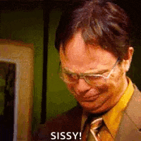 a man in a suit and tie is wearing glasses and making a funny face .