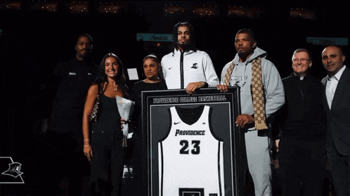 a man holding a providence jersey number 23