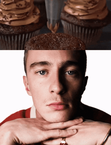 a close up of a man 's face with cupcakes behind him