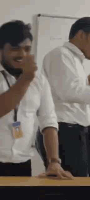 two men are standing next to each other in a room .