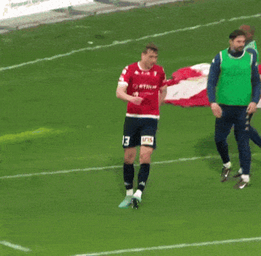 a soccer player in a red jersey with the number 13 on it