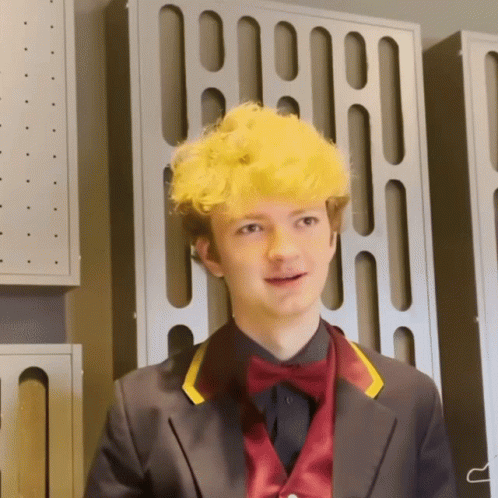 a young man with yellow hair and a bow tie