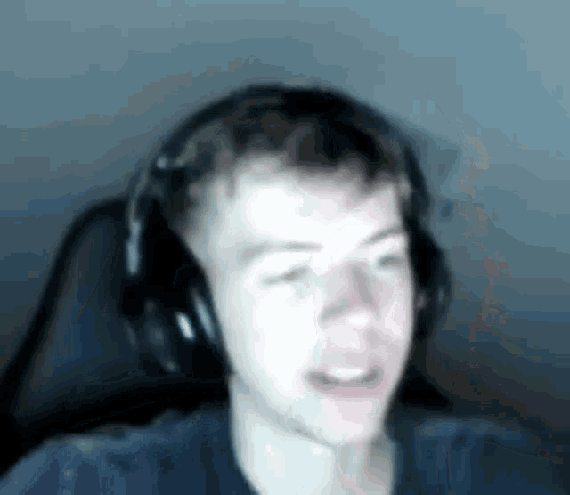 a young man wearing headphones is sitting in a chair in front of a computer screen .