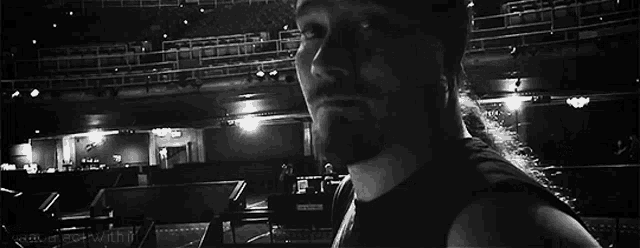 a black and white photo of a person standing in front of a stage .
