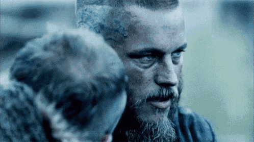 a close up of a man with a beard and a woman standing next to him .