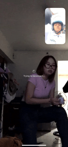 a girl is sitting in front of a phone screen that says trying to reconnect