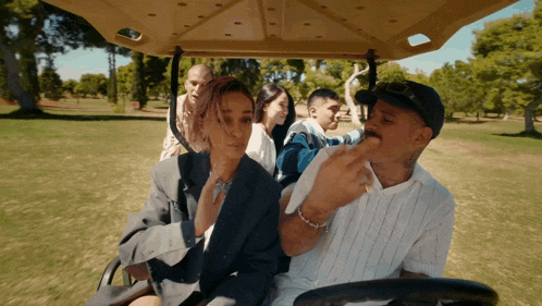 a group of people riding in a golf cart