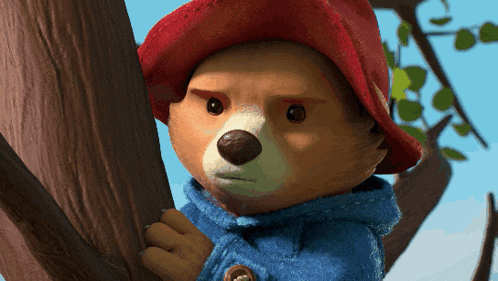 a teddy bear wearing a red hat and blue coat
