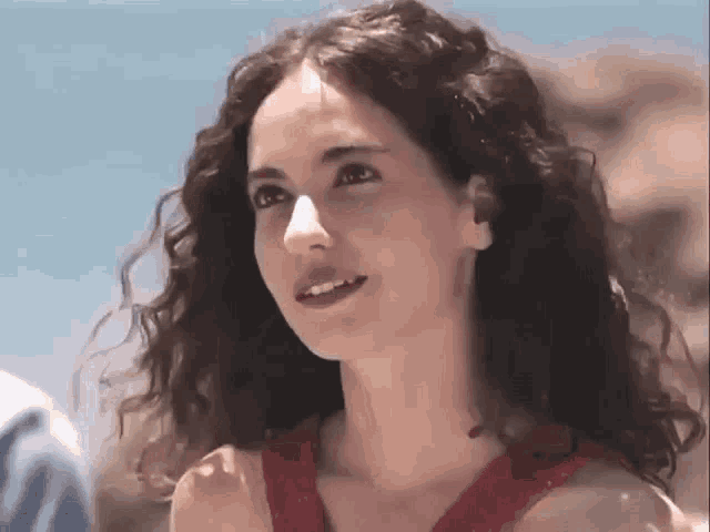 a woman with curly hair wearing a red dress