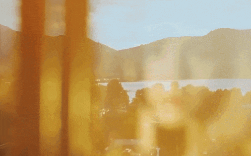 a view of mountains and a lake through a window