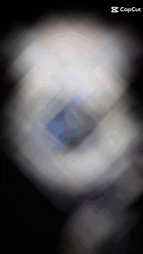 a blurred image of a person 's face with a capcut logo in the corner