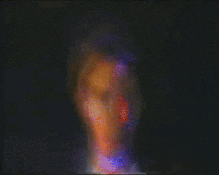 a blurry picture of a person in a dark room with a rainbow of colors