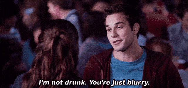 a man is talking to a woman in a crowd and says i 'm not drunk you 're just blurry