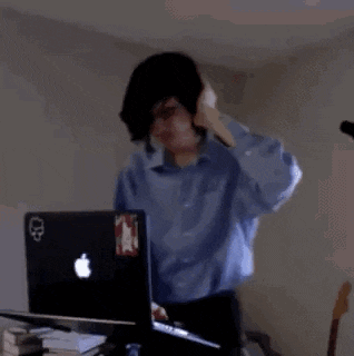 a man is standing in front of a laptop computer .