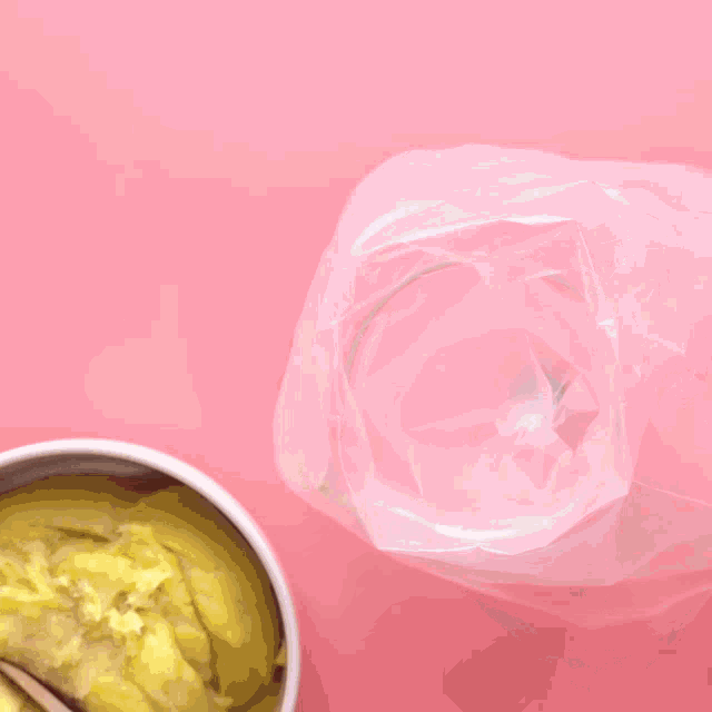 a person is holding a plastic bag of food with a spoon in it