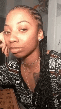 a woman with braids is wearing a sweater that says victoria 's secret on it .