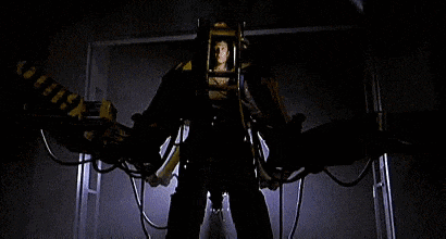 a man is standing in front of a machine that looks like a robot with wings .
