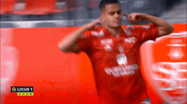 a soccer player wearing a red shirt that says ligue 1