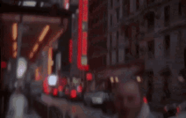a blurry photo of a man walking down a city street