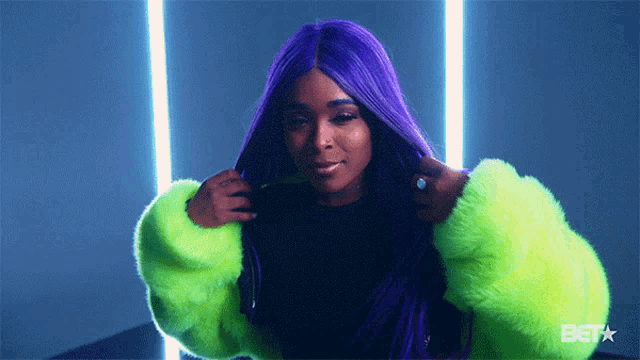 a woman with purple hair wearing a neon green jacket