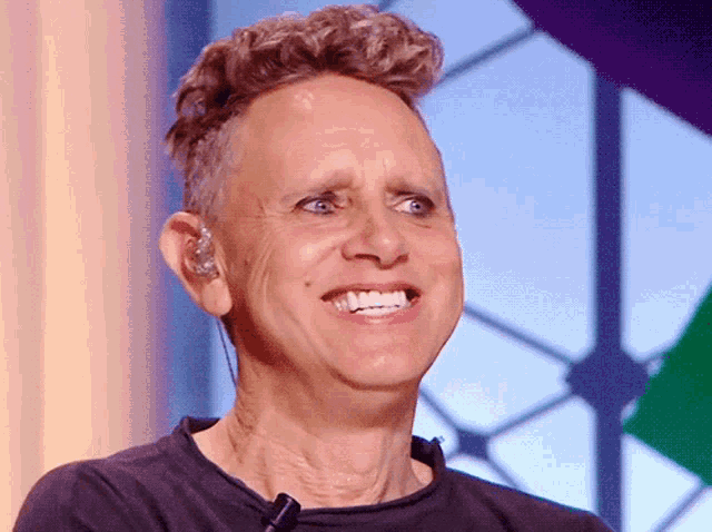 a man wearing ear buds is smiling and looking at the camera