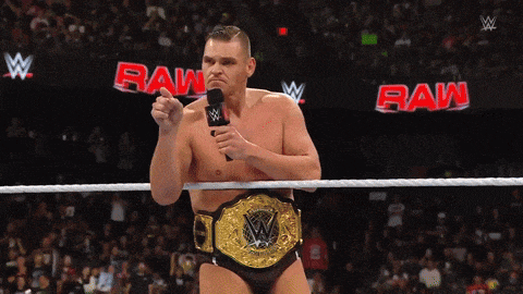 a man in a wrestling ring holding a microphone with the word raw in the background