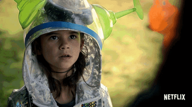 a little girl is wearing a helmet and a netflix logo
