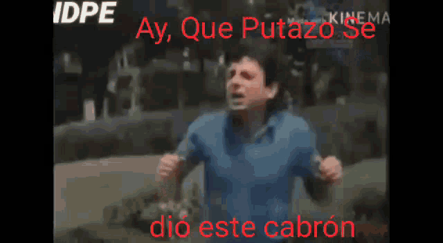 a man in a blue shirt is running with the words ay que putazo se dio este cabron in red