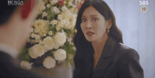 a woman is making a funny face while talking to a man .