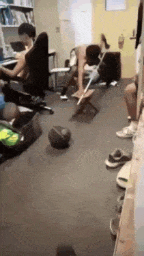 a group of people are sitting around a table in a room with a basketball on the floor .