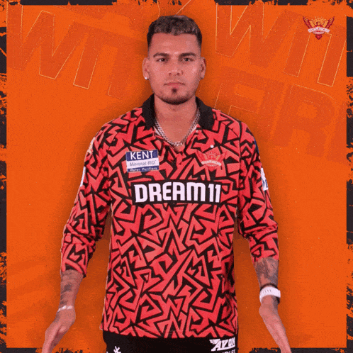 a man wearing a red shirt that says dream11