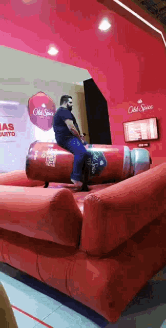 a man is riding an inflatable bottle of old spice deodorant .