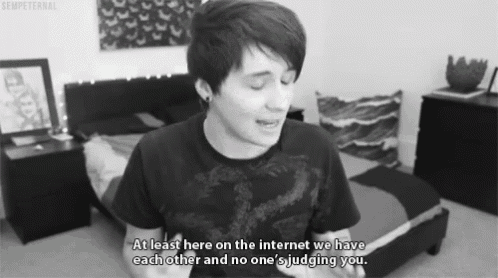 a black and white photo of a man in a bedroom with the caption at least here on the internet we have each other