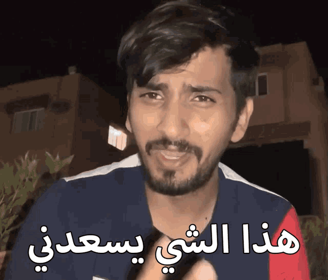 a man with a beard and arabic writing on his shirt