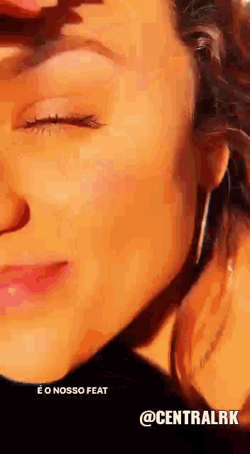 a close up of a woman 's face with the words e o nosso feat @centralrk at the bottom