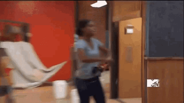 a blurred image of a woman dancing in a hallway with a mtv logo in the corner