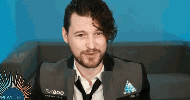 a man in a suit and tie with rk800 written on his jacket