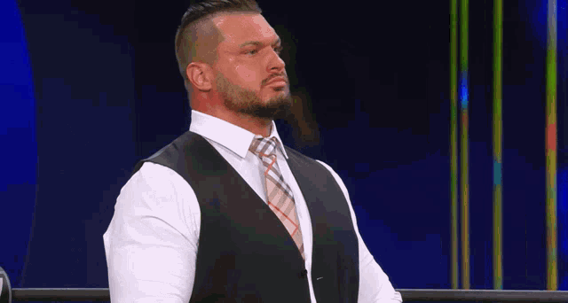 a man in a suit and tie stands in a ring