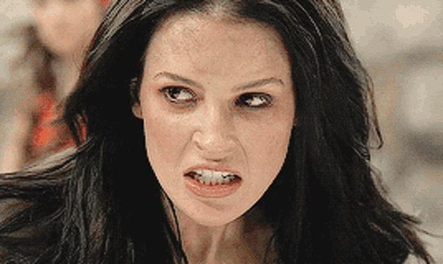 a close up of a woman 's face with her mouth open
