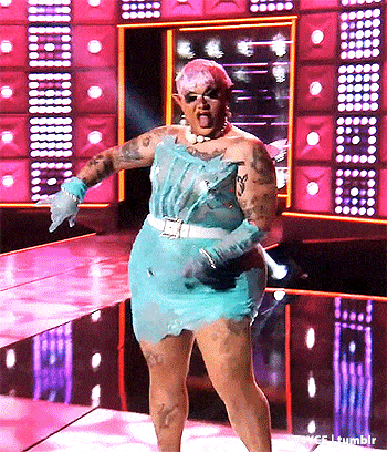 a drag queen is dancing on a stage wearing a blue dress .
