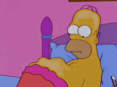 homer simpson is laying in a bed with a pink blanket