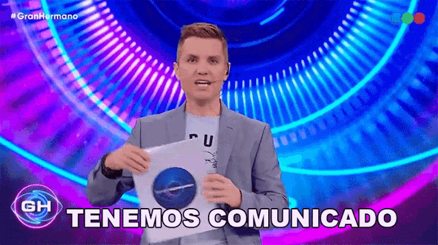 a man in a suit is holding a piece of paper that says tenemos comunicado on it