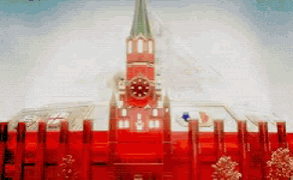 a red building with a clock tower and a flag in front of it
