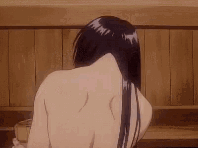 a naked woman with long black hair is taking a bath in a wooden room .