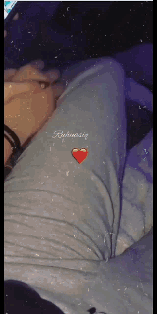 a person holding another person 's hand with a red heart and the word rapuasiq written on the bottom