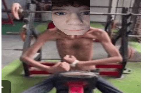 a young boy without a shirt is sitting in a gym with his arms crossed .