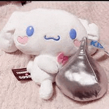a stuffed animal is sitting next to a hershey kiss candy .