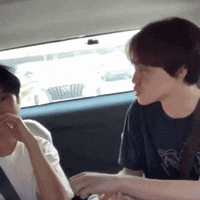 two men are sitting in the back seat of a car talking to each other