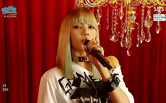 a woman singing into a microphone with sbs on the bottom right