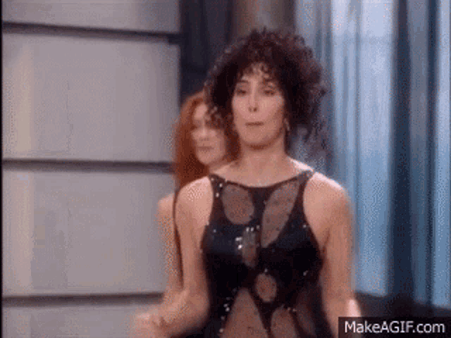 a woman in a black dress is dancing with another woman in a red dress .